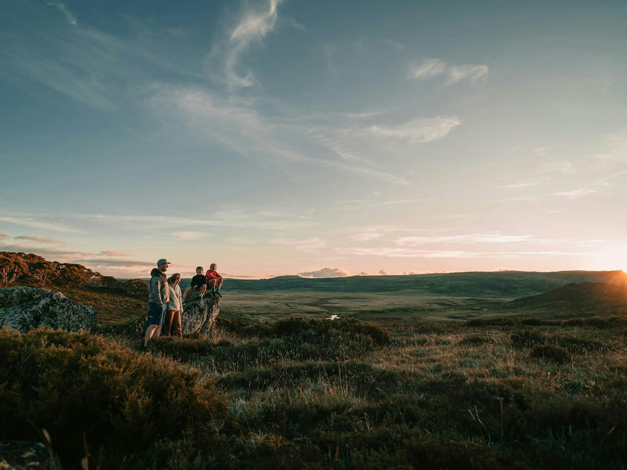 Family pauses to watch sunset as they high in the mountain high plains
