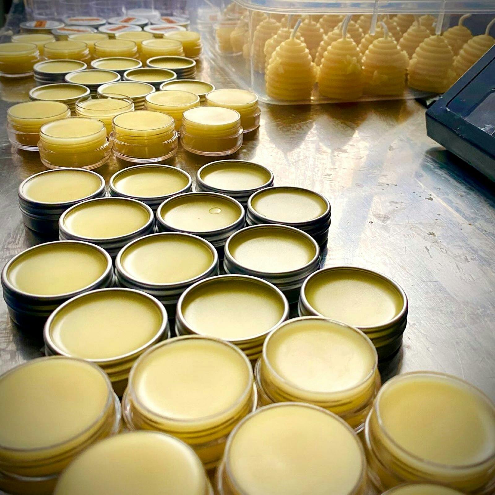 Handmade beeswax candles and lipbalms setting on table.