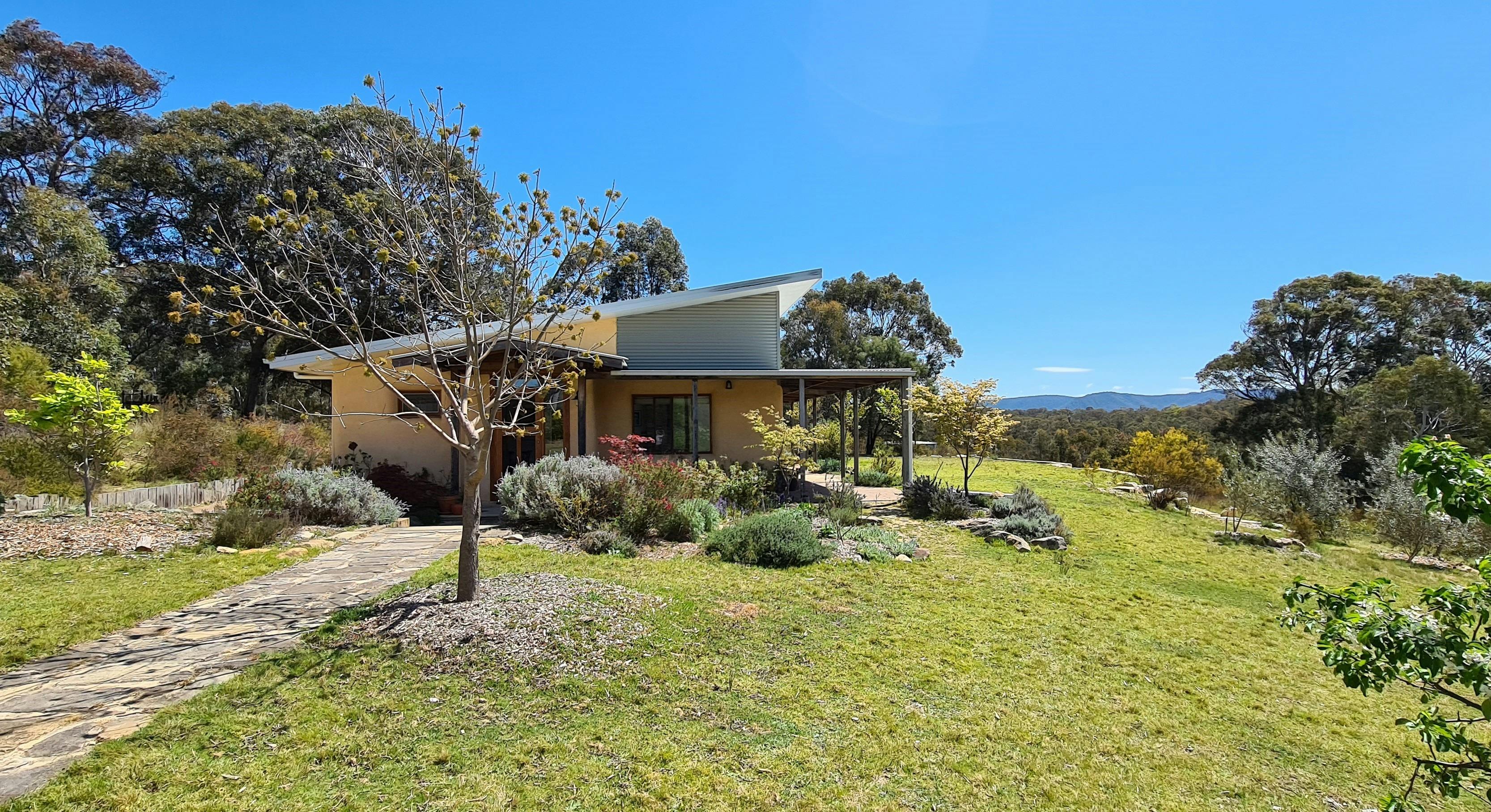 Entry to the Strawhouse through  ornamental gardens. Pear trees and lawn for picnics and games.
