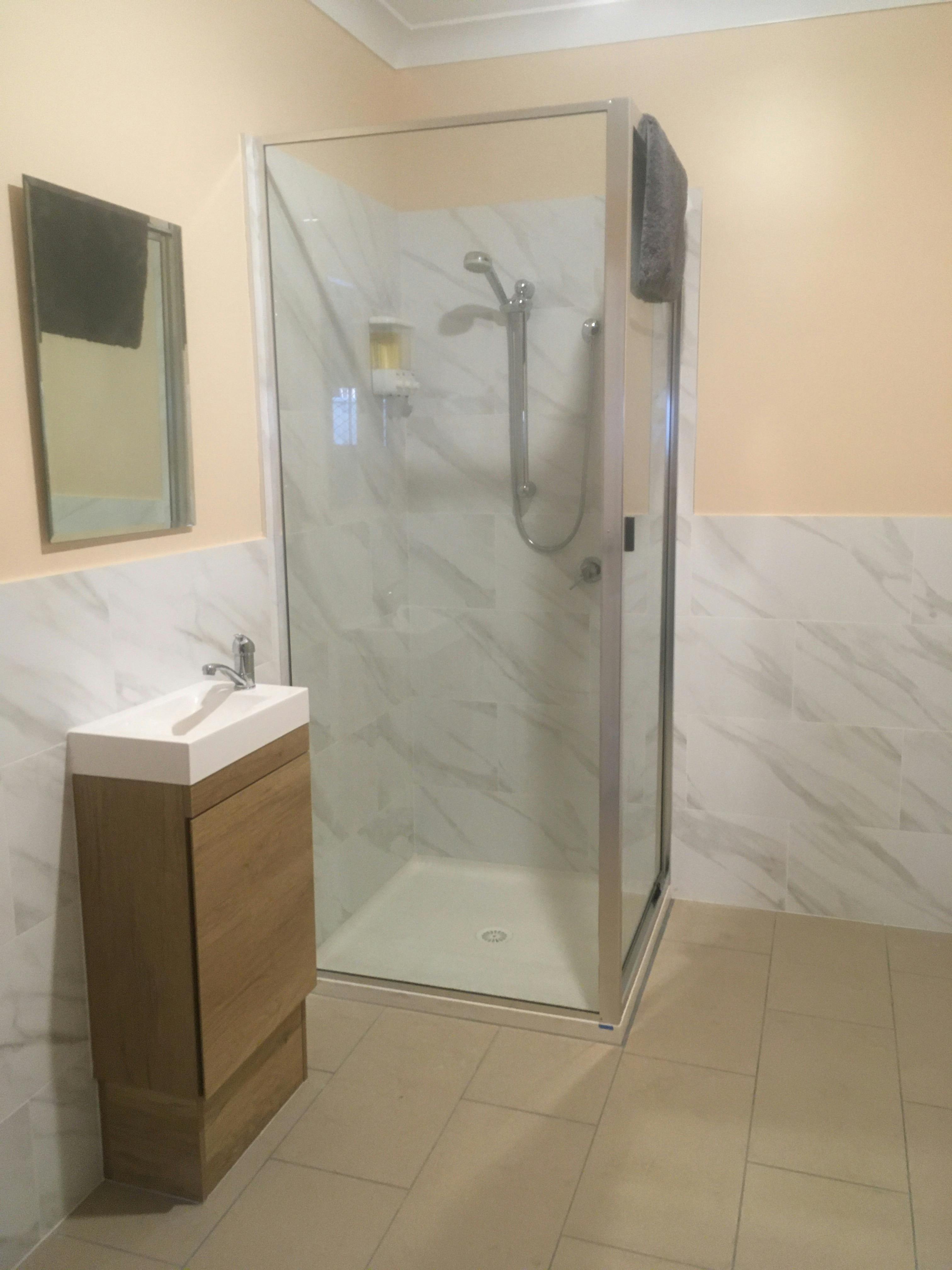 シャワーと洗面化粧台を備えたバスルーム