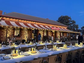 a long table is set for dining outside of a hotel