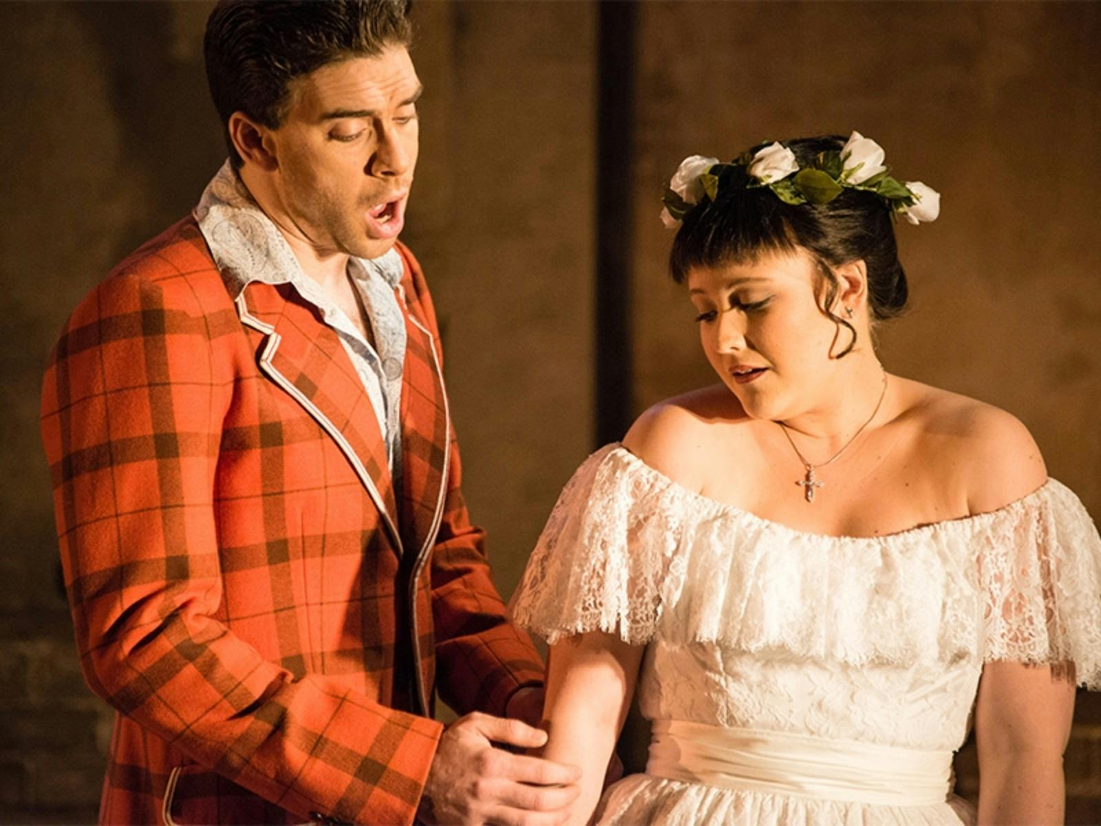 man in red and black checked jacket and lady in off-sholder cream lace dress