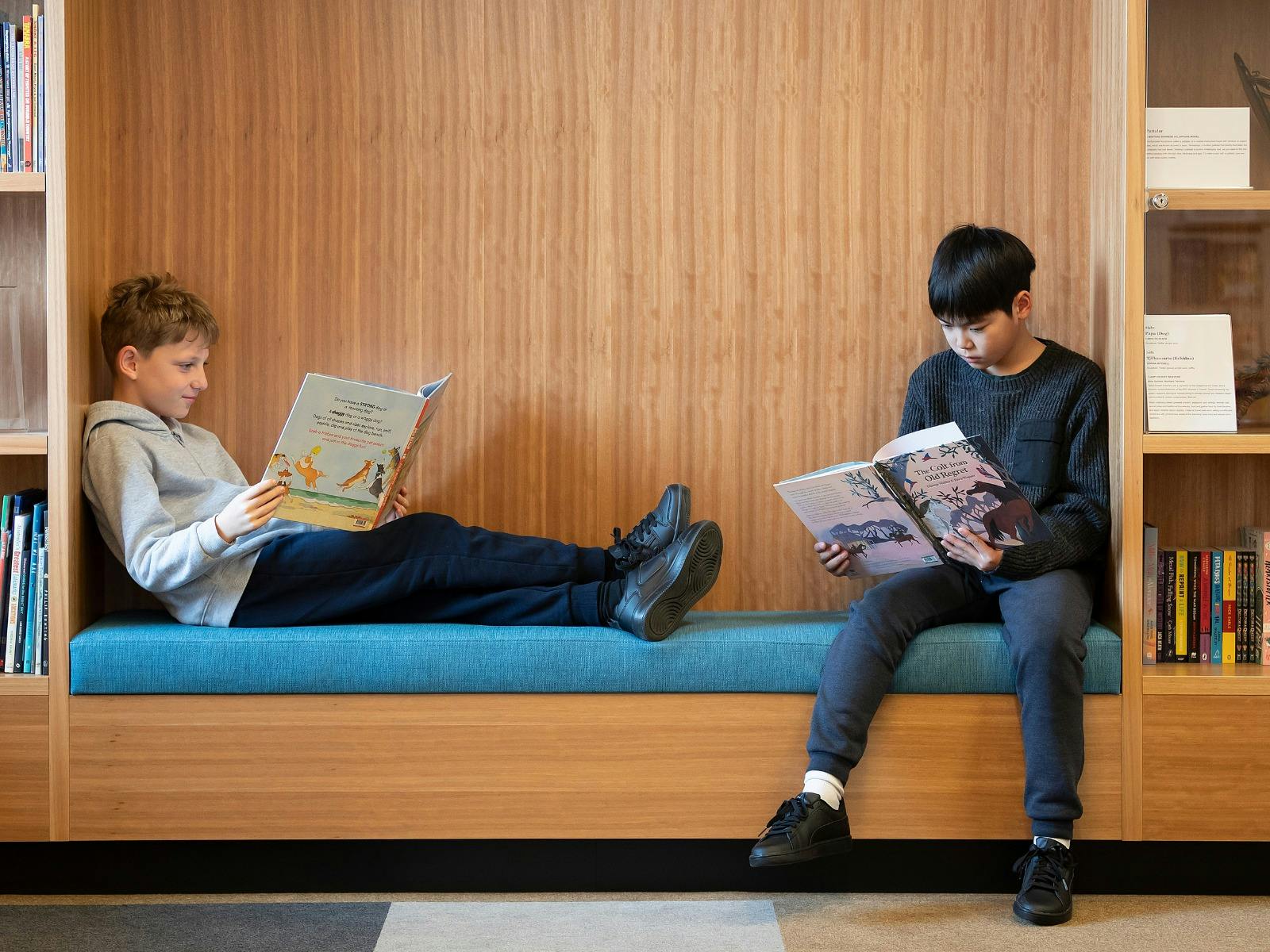 Two kids sitting down and reading NLA Publishing picture books.