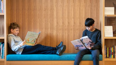 Two kids sitting down and reading NLA Publishing picture books.