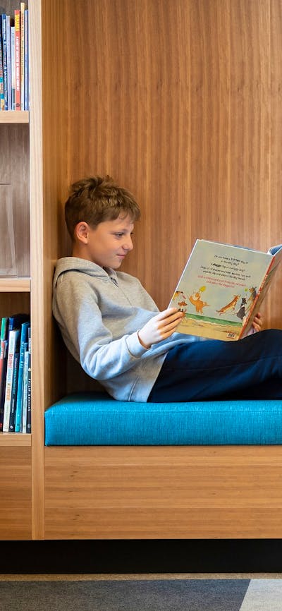 Two kids sitting down and reading NLA Publishing picture books.