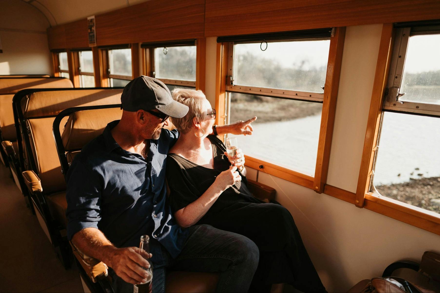 couple looking out window of rail motors onto river