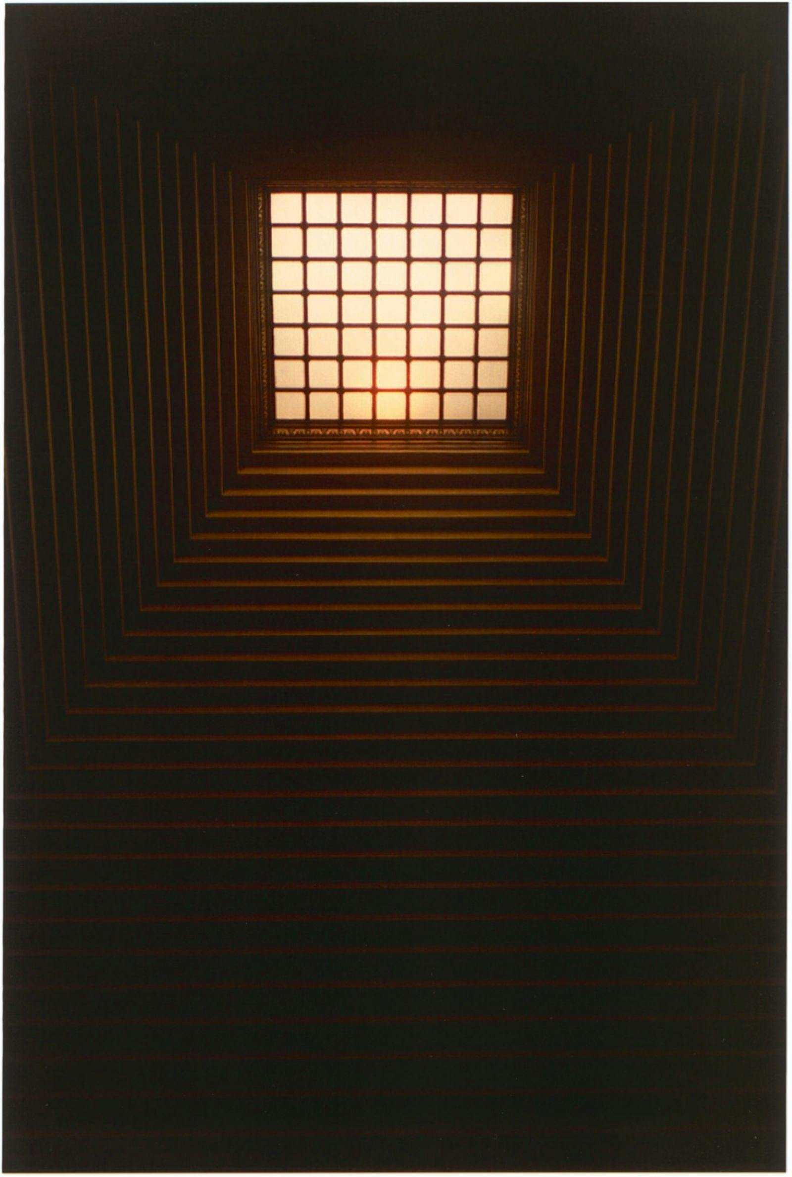 Light filtering in through a grid of squares in the distance.