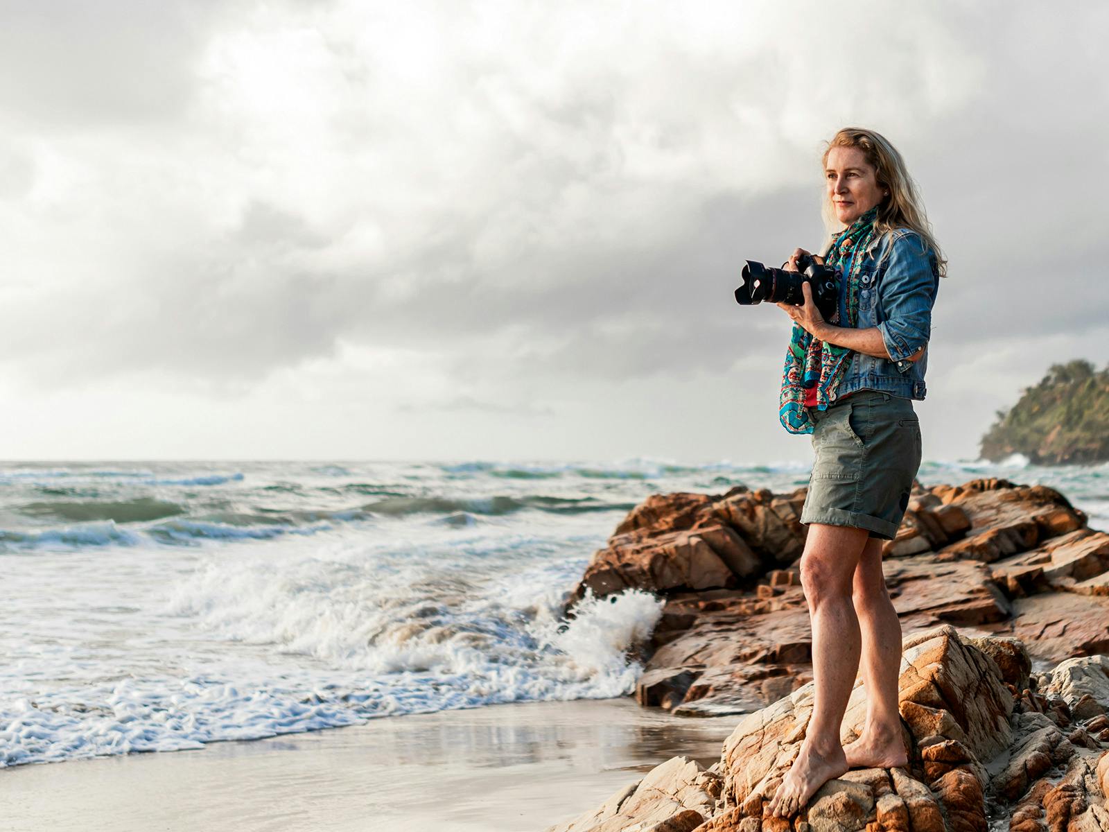 Photographer standing on rocks at Coolum Beach, Sunshine Coast, Queensland.