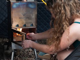 Person lighting the fire in the Soulfire wood fire sauna