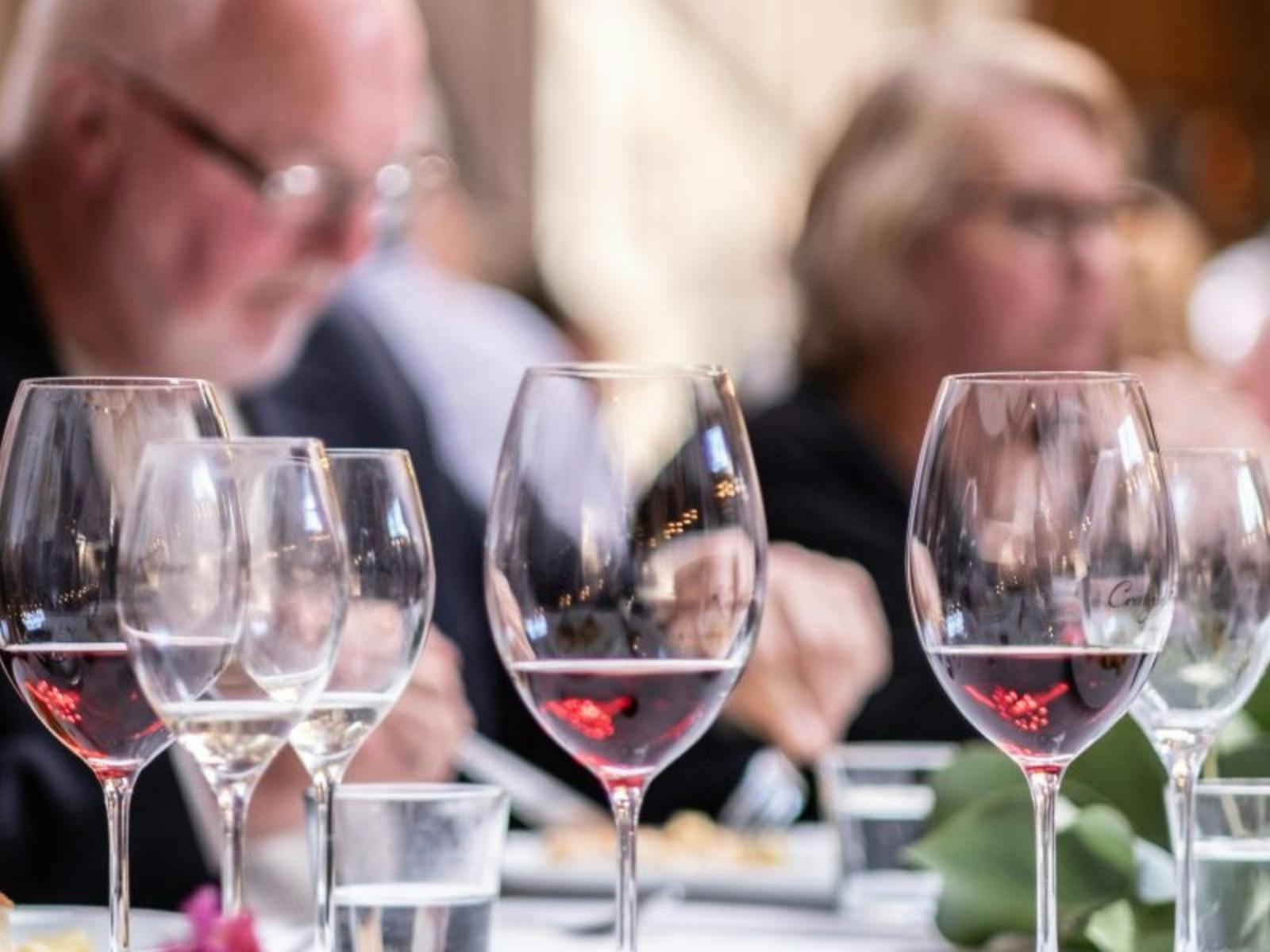 Diners at a long table with an array of Craigie Knowe wine glasses and wines
