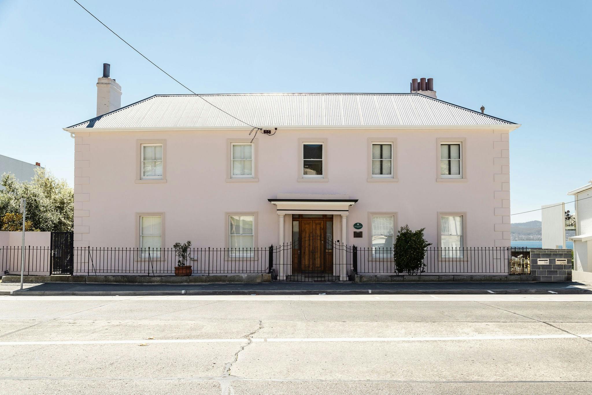 Facade of Maison Del Mar a beautiful pink Georgian heritage building in Sandy Bay