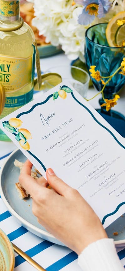 Prix fixe menu on blue and yellow table setting