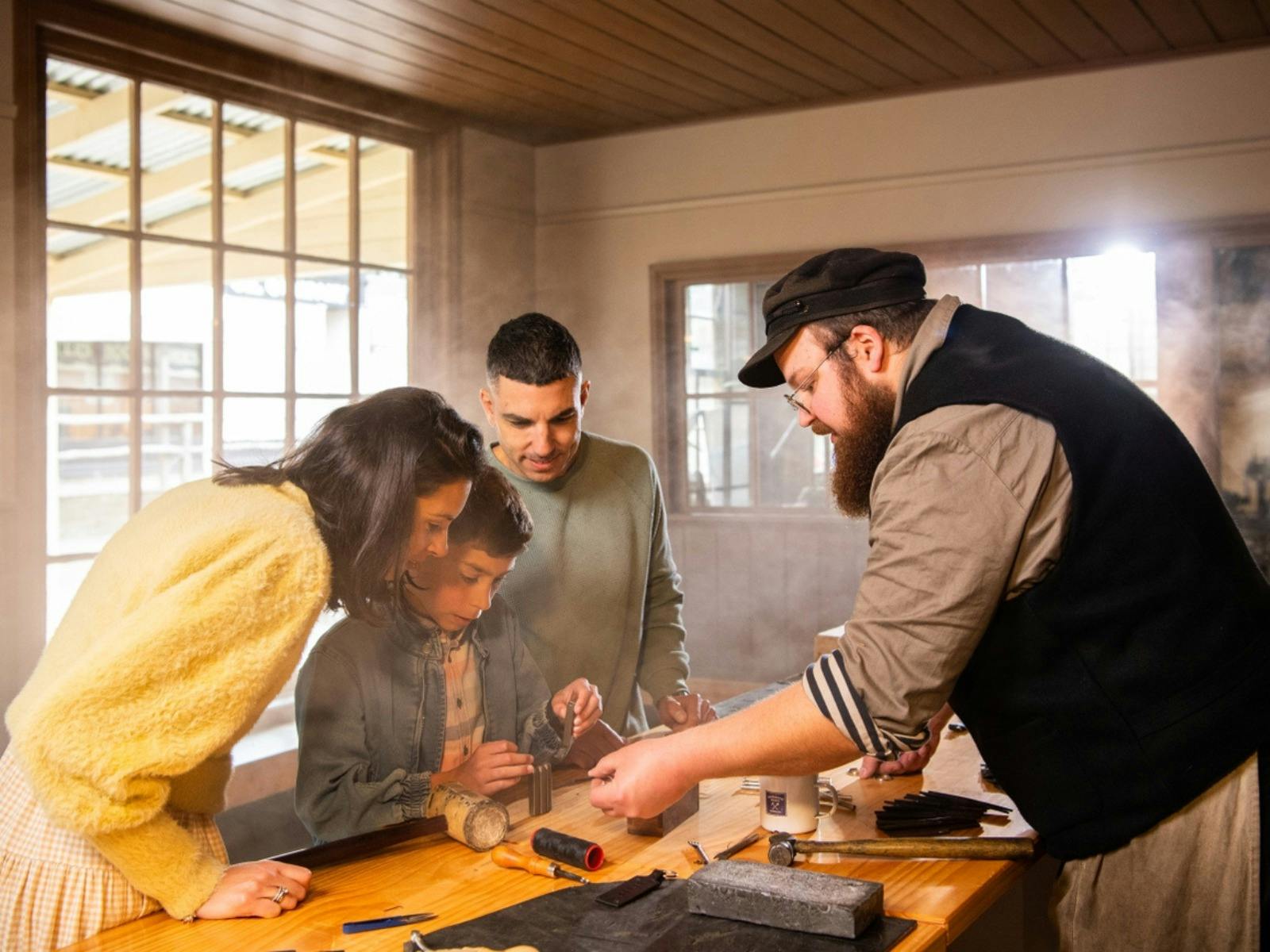 Family making keyring with Sovereign Hill leather-maker inside workshop