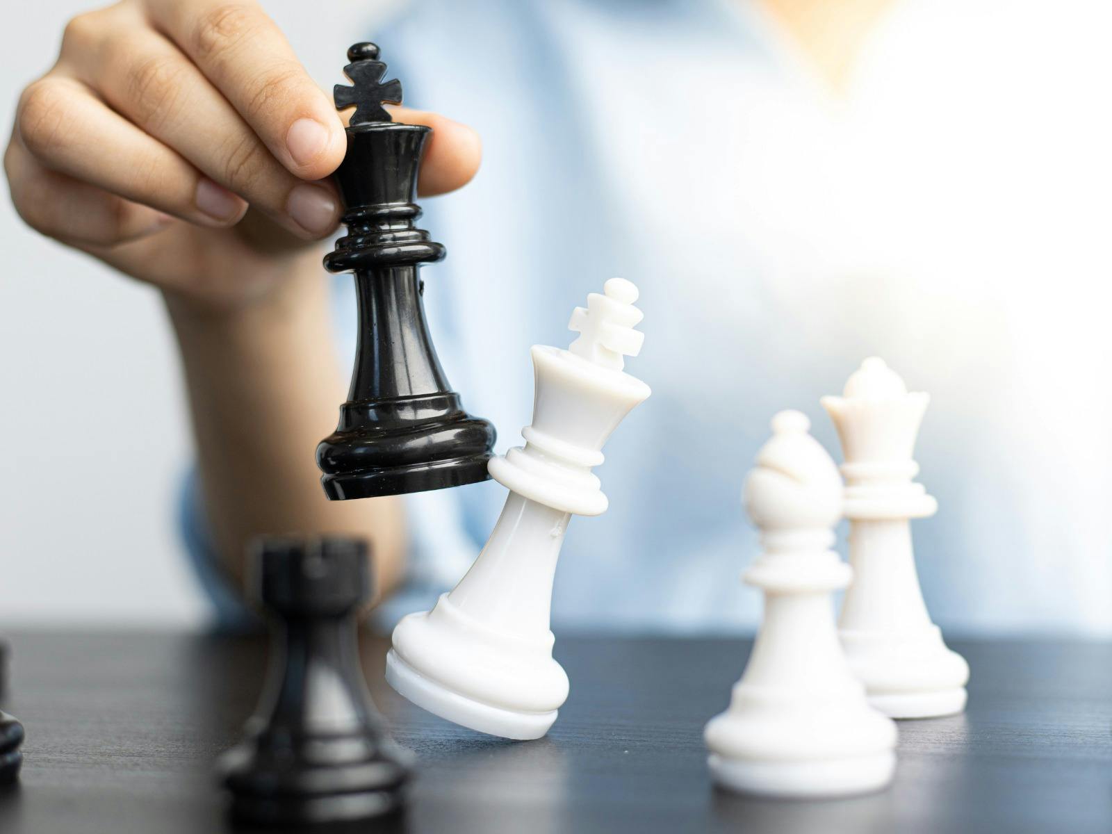 Chess peices and person holding a chess peice