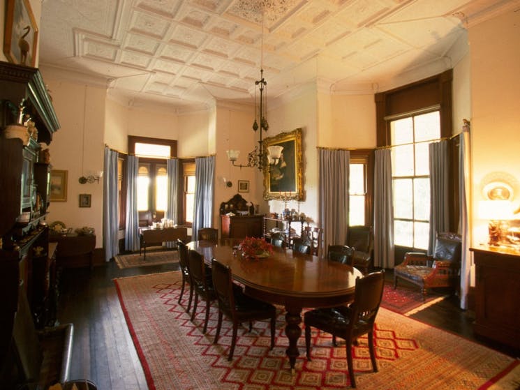 1842 building with detailed ceiling and all original wooden furniture in place. Large dining table.