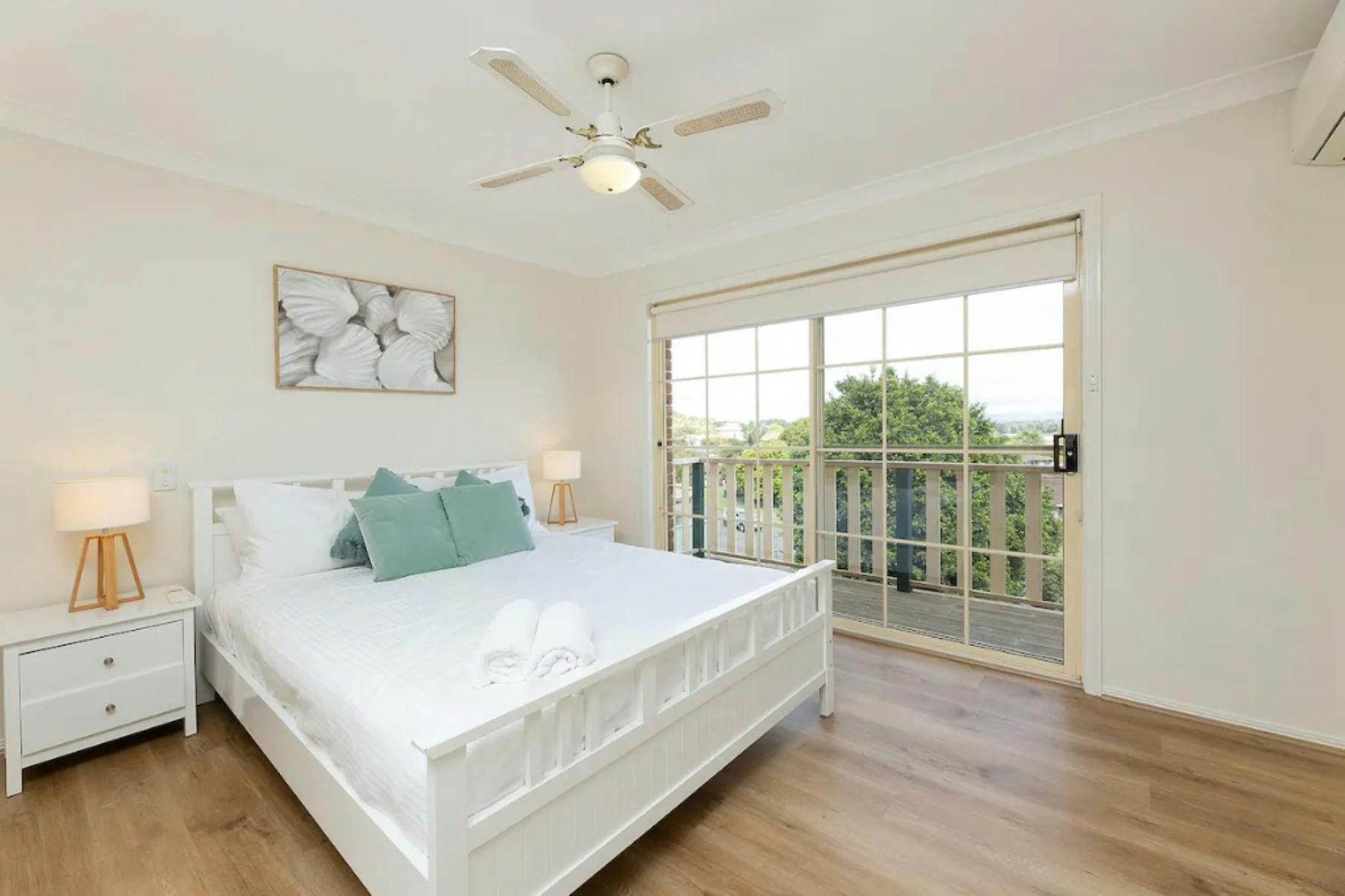 Master bedroom with ceiling fan and balcony access