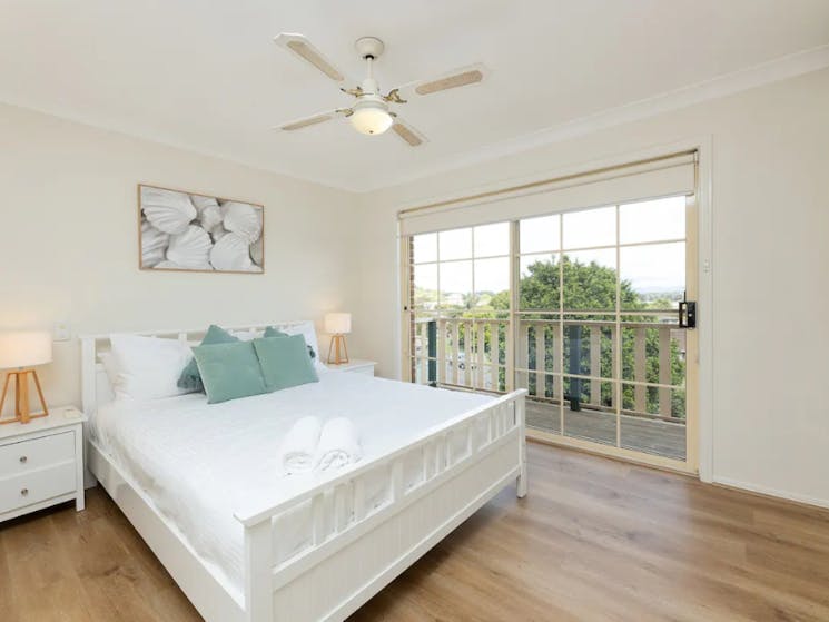 Master bedroom with ceiling fan and balcony access