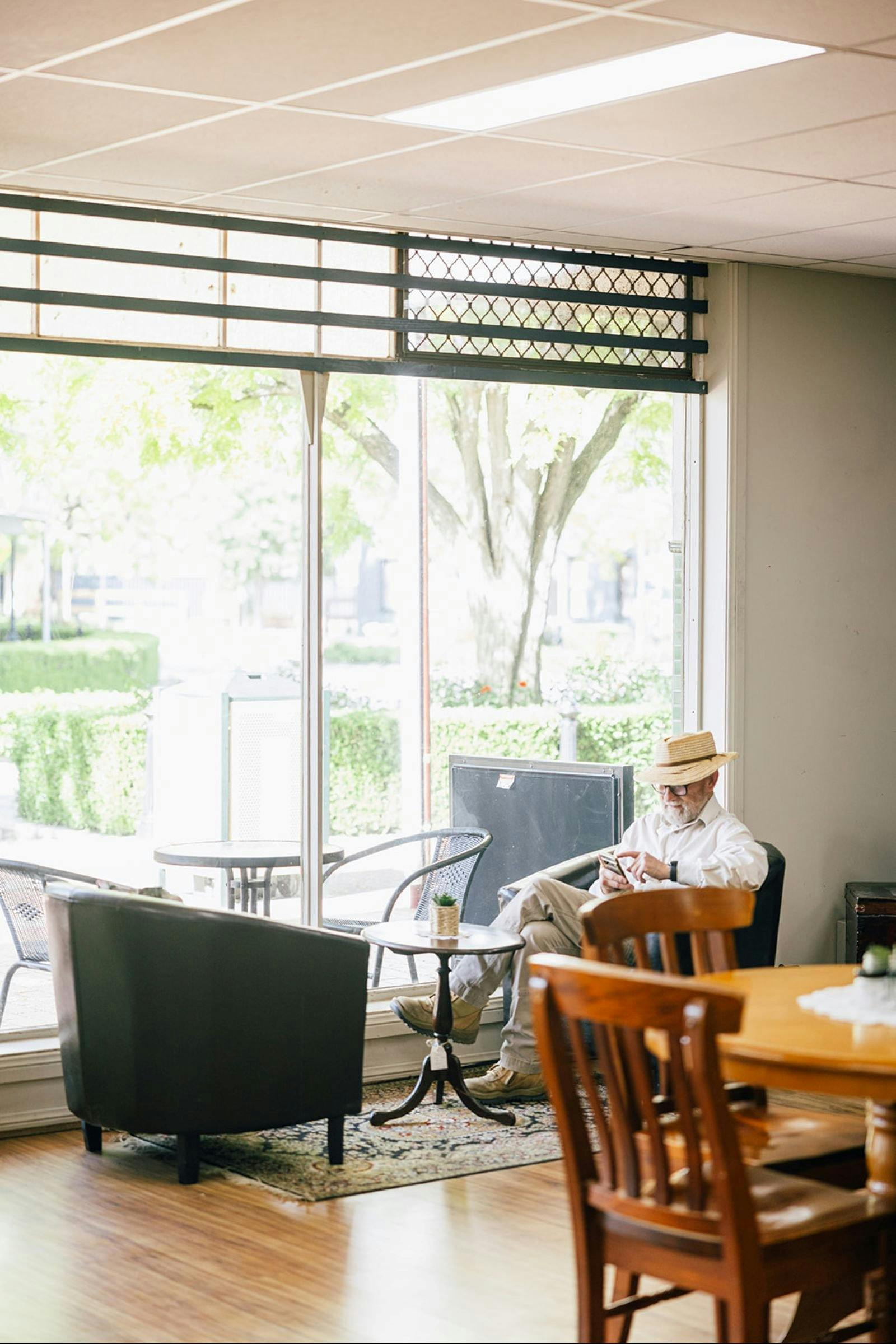 Gentleman sitting at the table at the front window of cafe