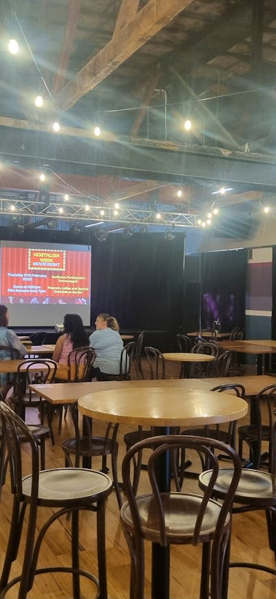 Tables and chairs with the screen up on the stage