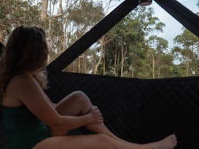 Person enjoying the warmth (and the view!) of the Soulfire wood fire sauna at Mountain Path Meadows.