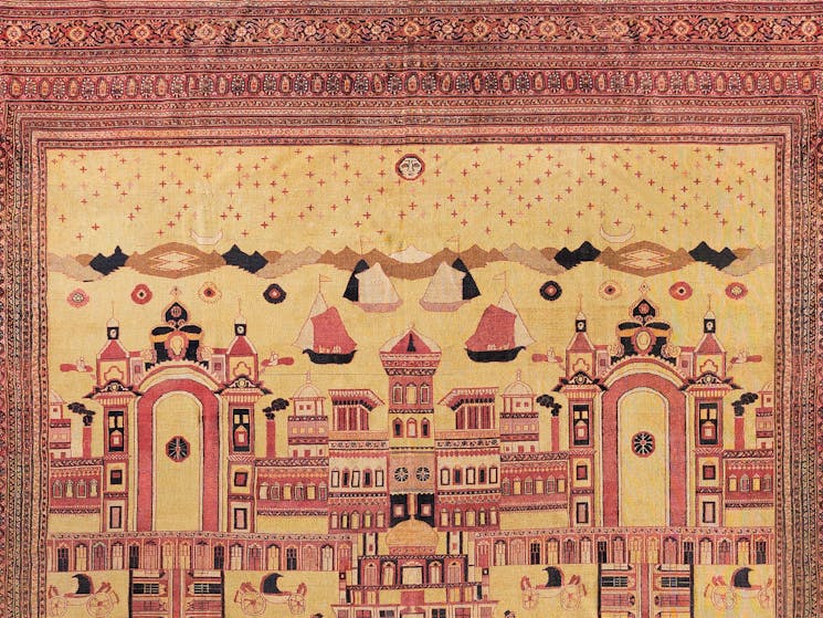 Terracotta and yellow-coloured Persian rug depicting mountains and buildings