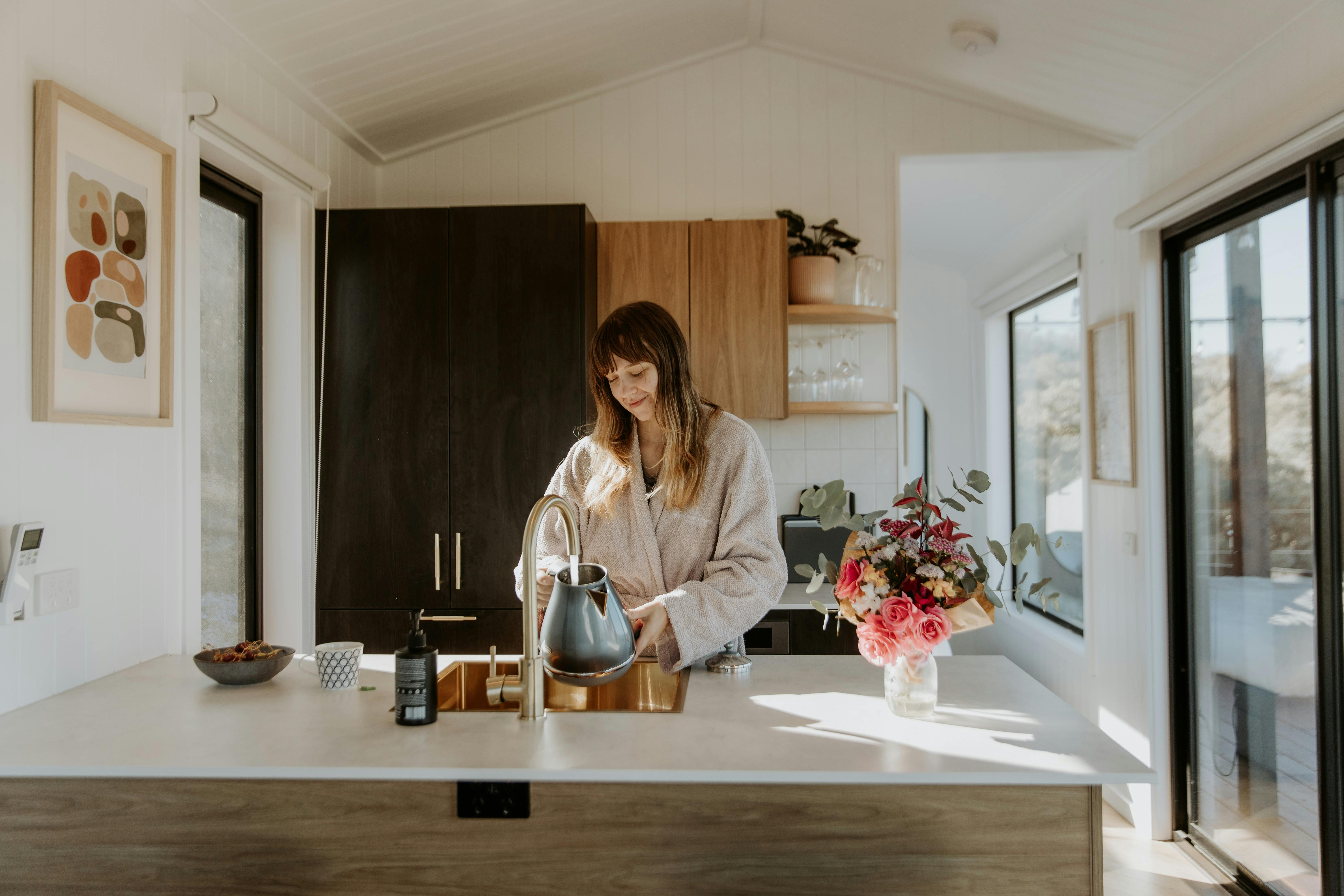 Woman making tea in beautifully appointed kitchen