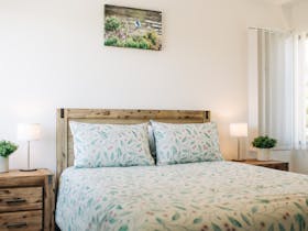 The master bedroom is upstairs and contains a queen bed as well as a built in wardrobe