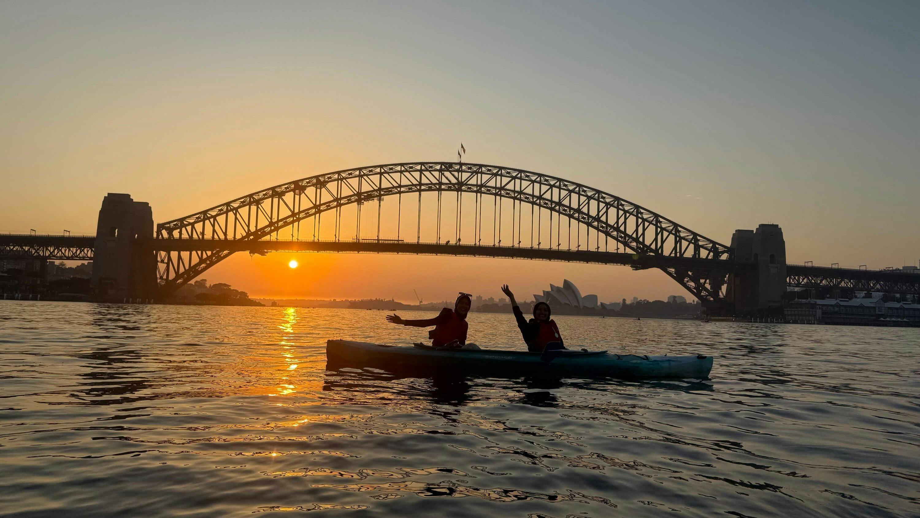 皮划艇旅行團在薰衣草灣附近平靜的水域上航行，遠處是海港大橋。