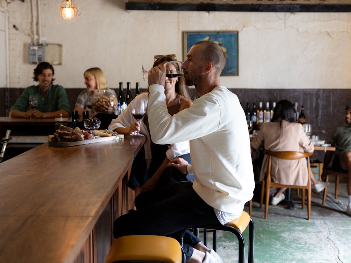 A drink at the bar with a cheese platter to match.