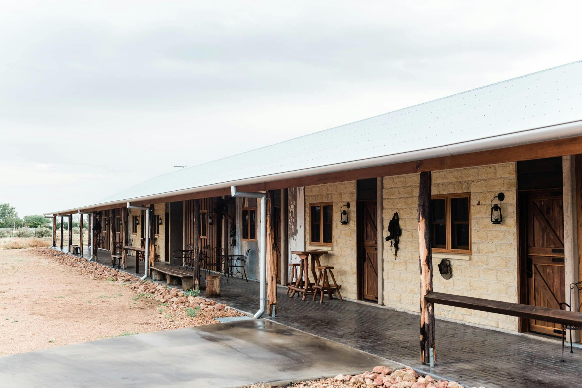Long single level building with cream brick walls and iron roof