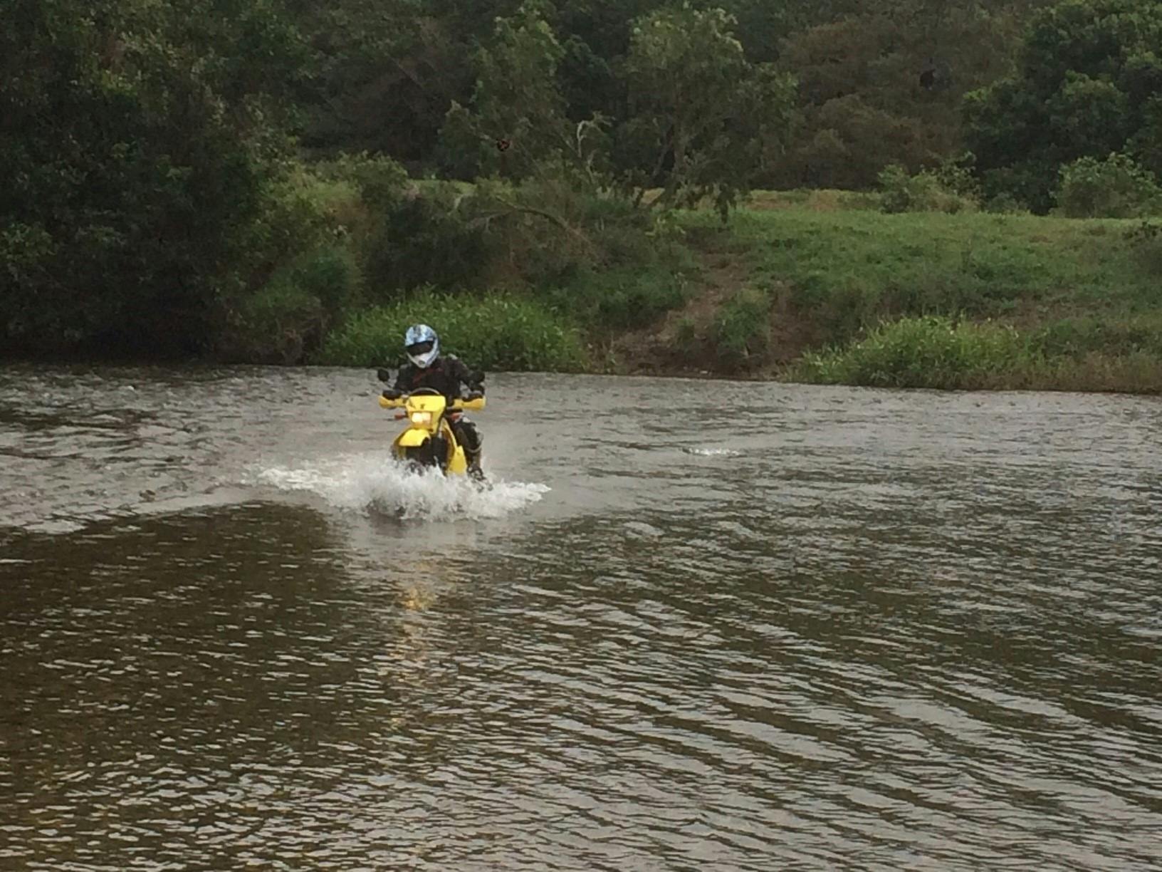 Motorcycle  riding through a water crossing Cairns to Cape York