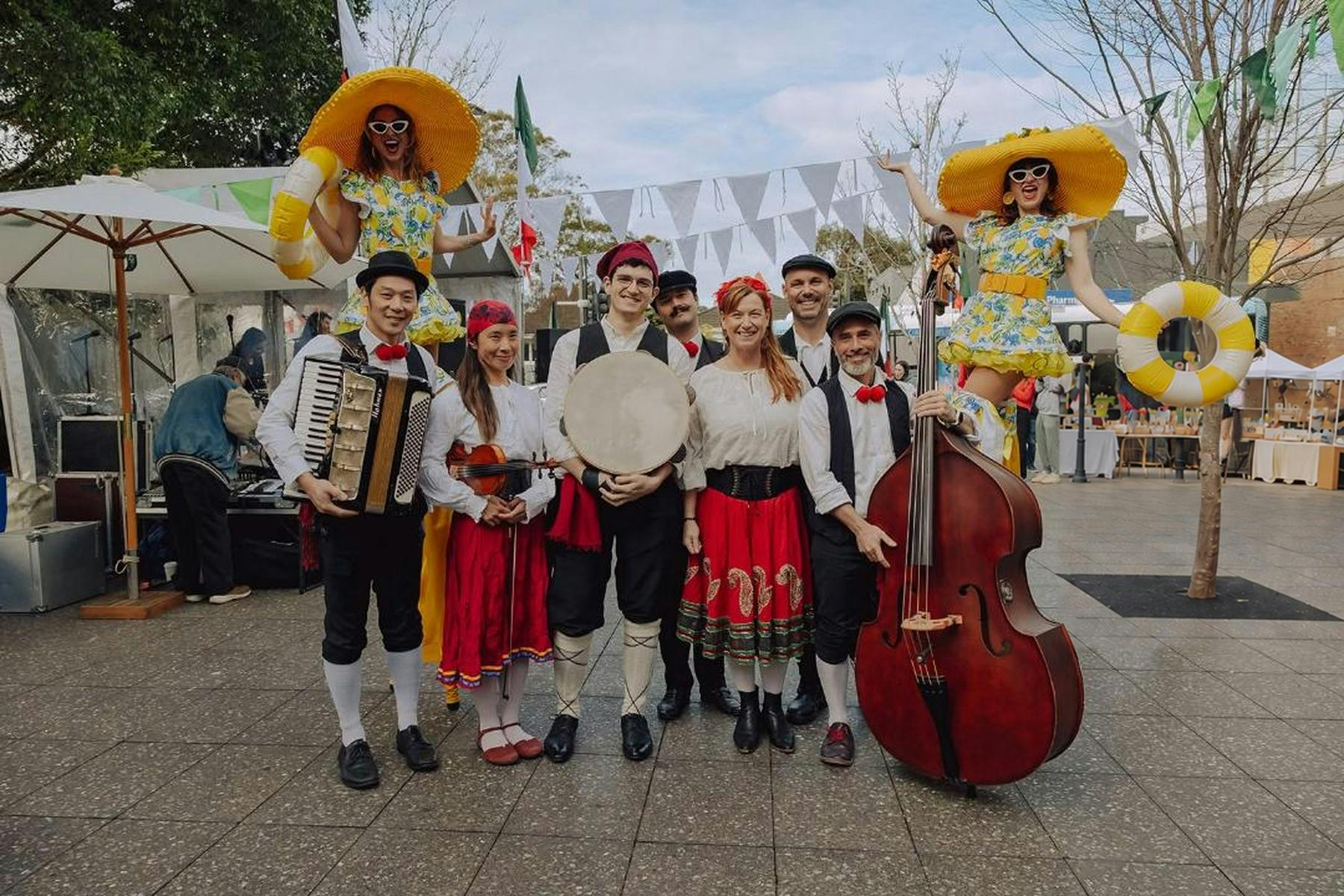 Scupriri musicians pose with their instruments at an outdoor market.