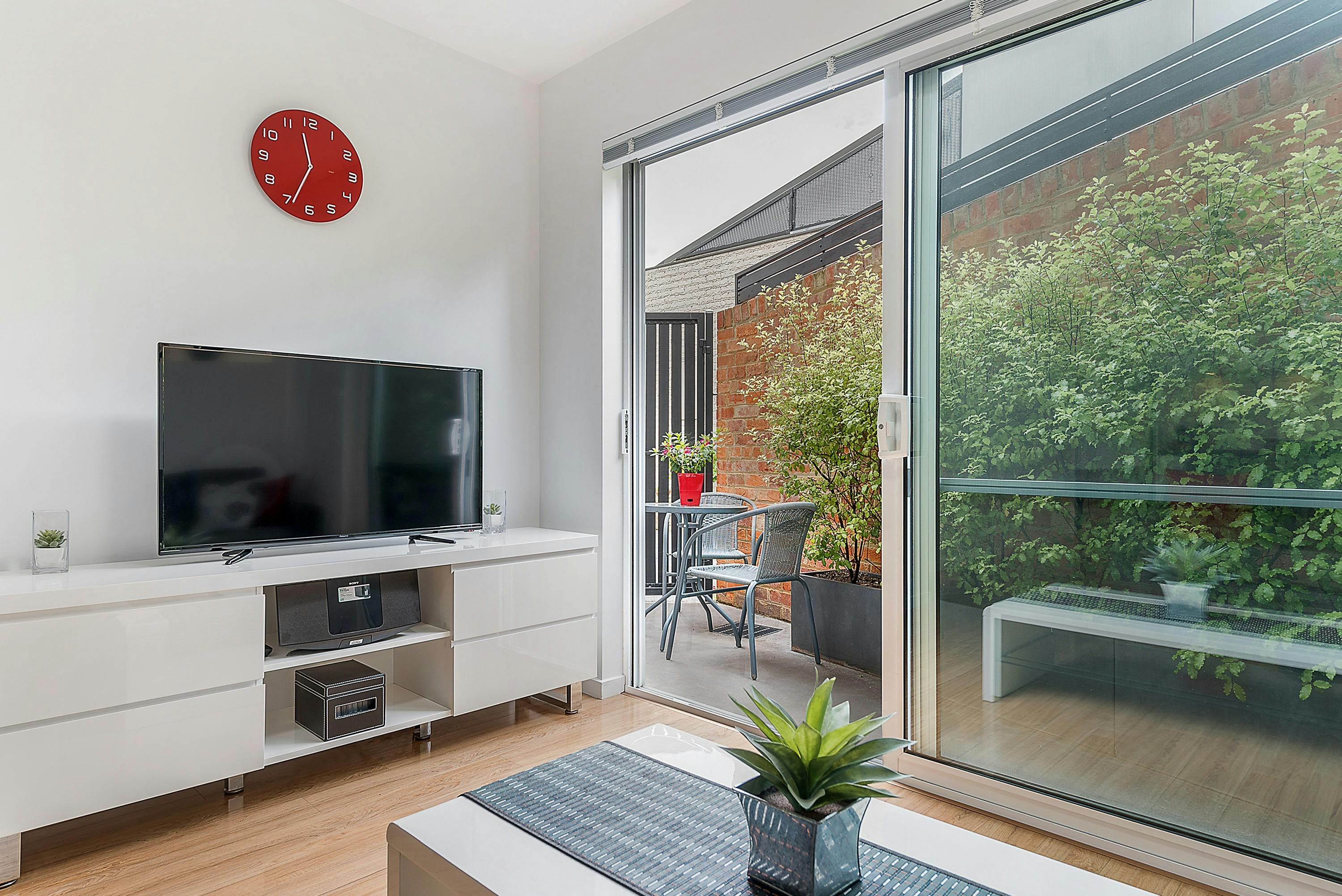 Spacious open-plan living area with comfortable seating and access to the private courtyard