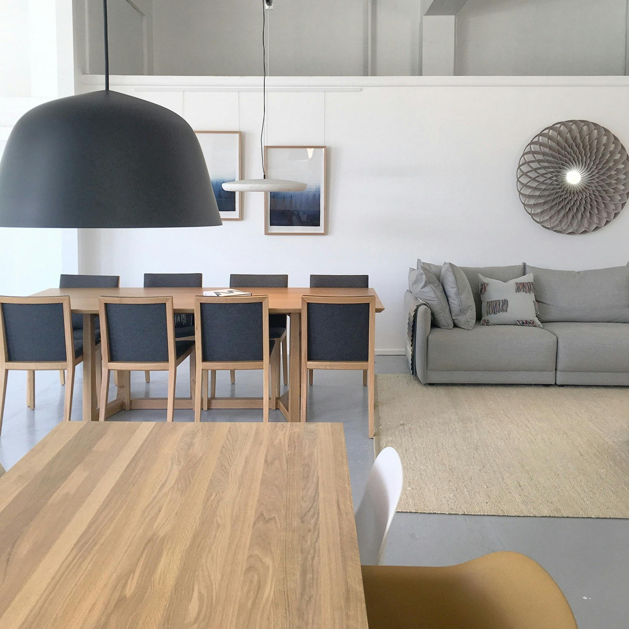 Showroom photo featuring dining tables and pendants.