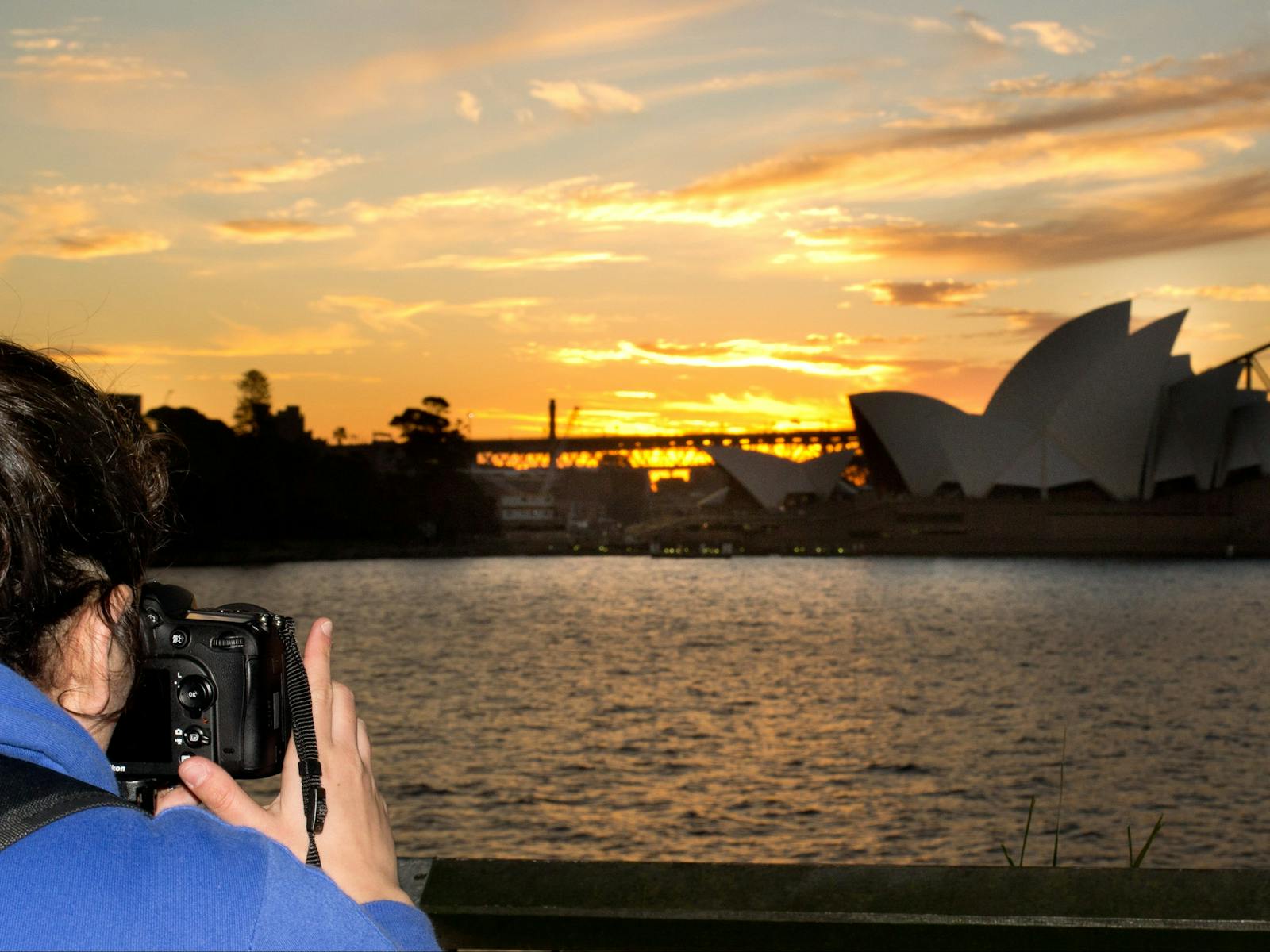 Sunset behind Opera House as photorapher takes photo