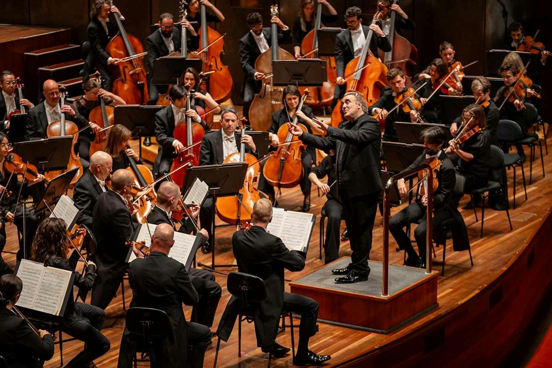 Orchestra performing on stage with conductor