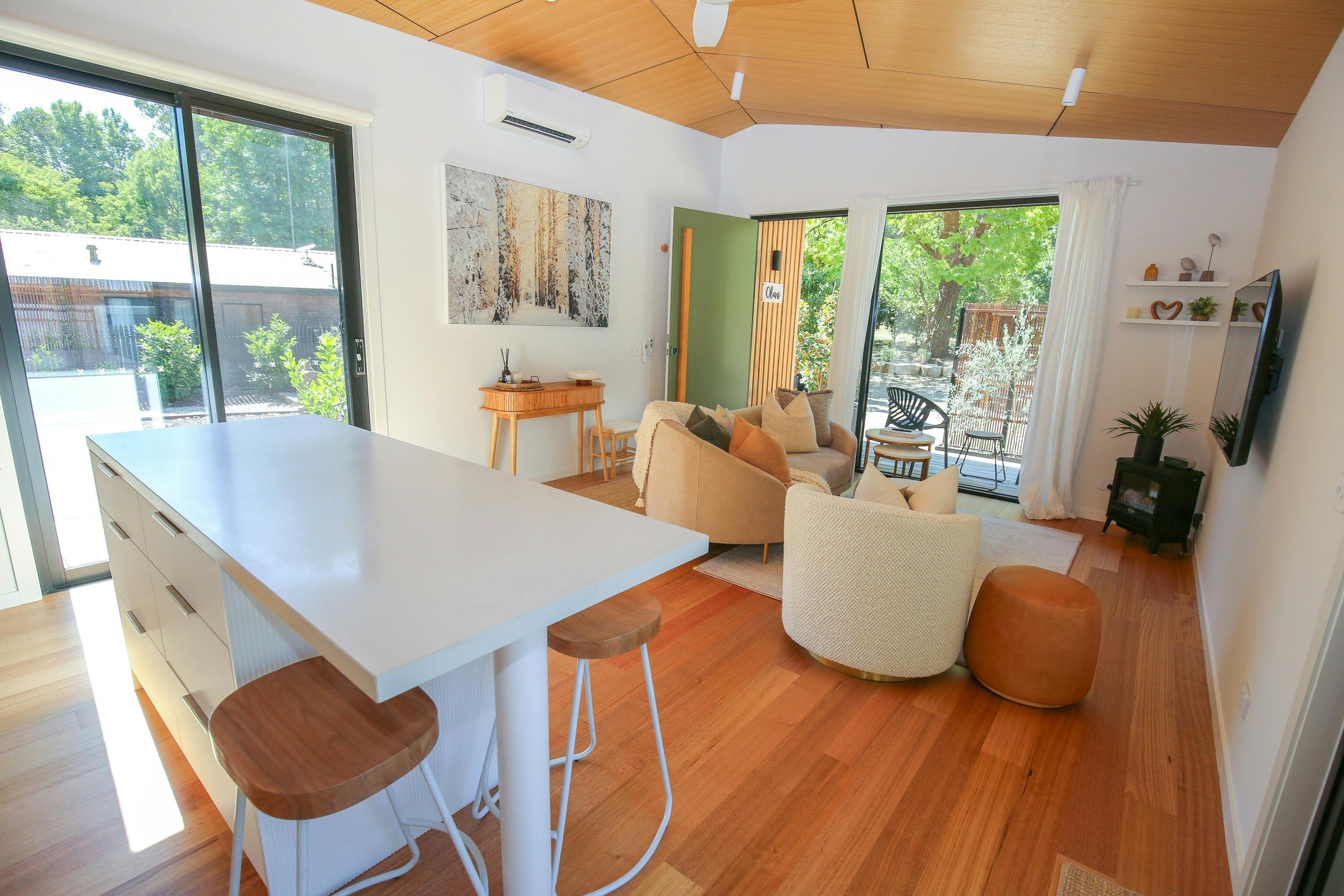 Living space with couches, table, stools and a television at Olive Retreat