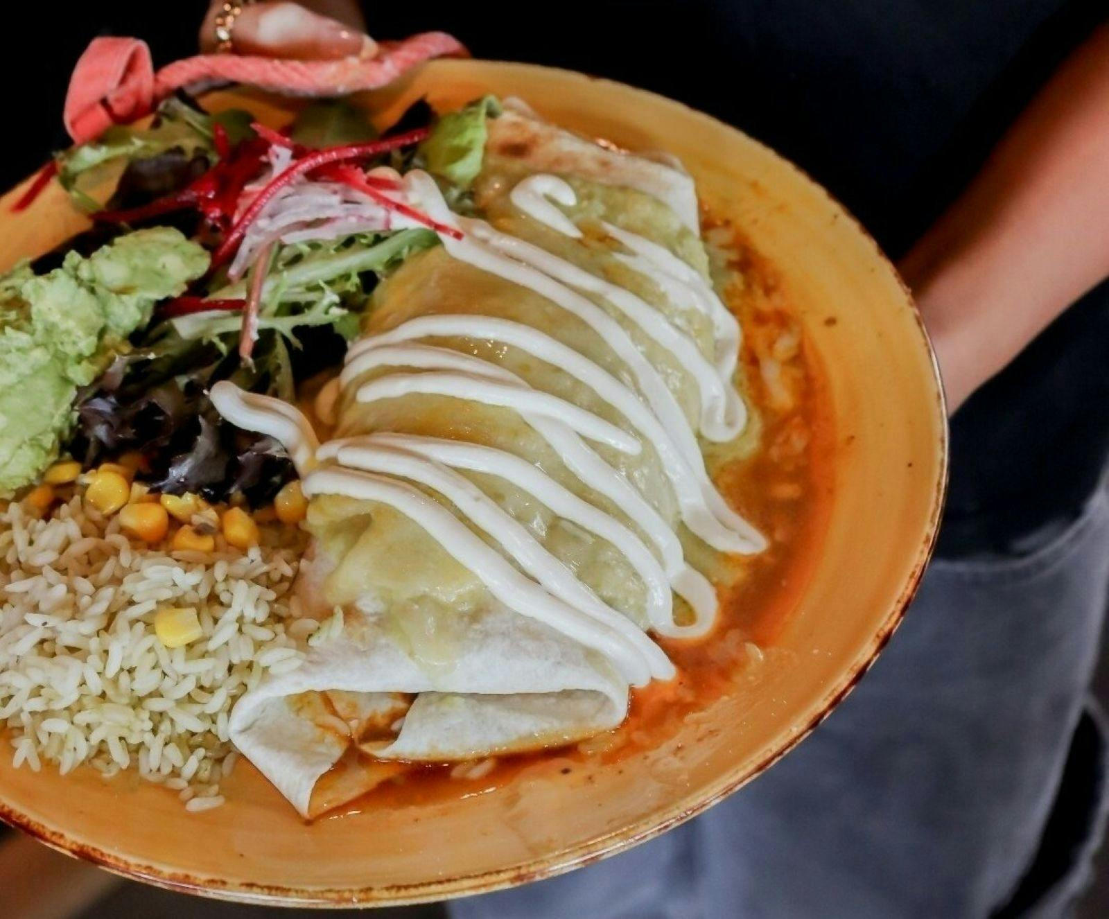 Envuelta | Flour tortilla, black beans, with verde salsa, grill cheese, crema, rice, guac & salad
