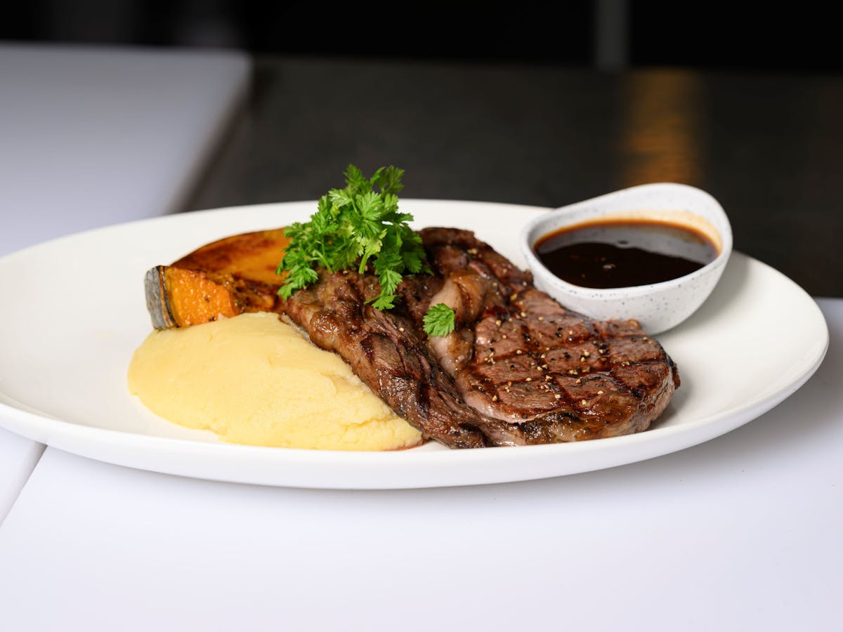 Steak, pumpkin, mashed potato and gravy on plate Steak, pumpkin, mashed potato and gravy on plate