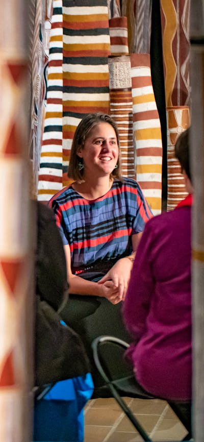 A tour group with an installation of 200 Aboriginal painted logs