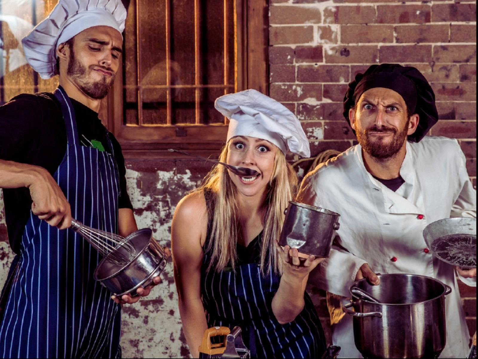 Three adult performers playing kitchen items as instruments