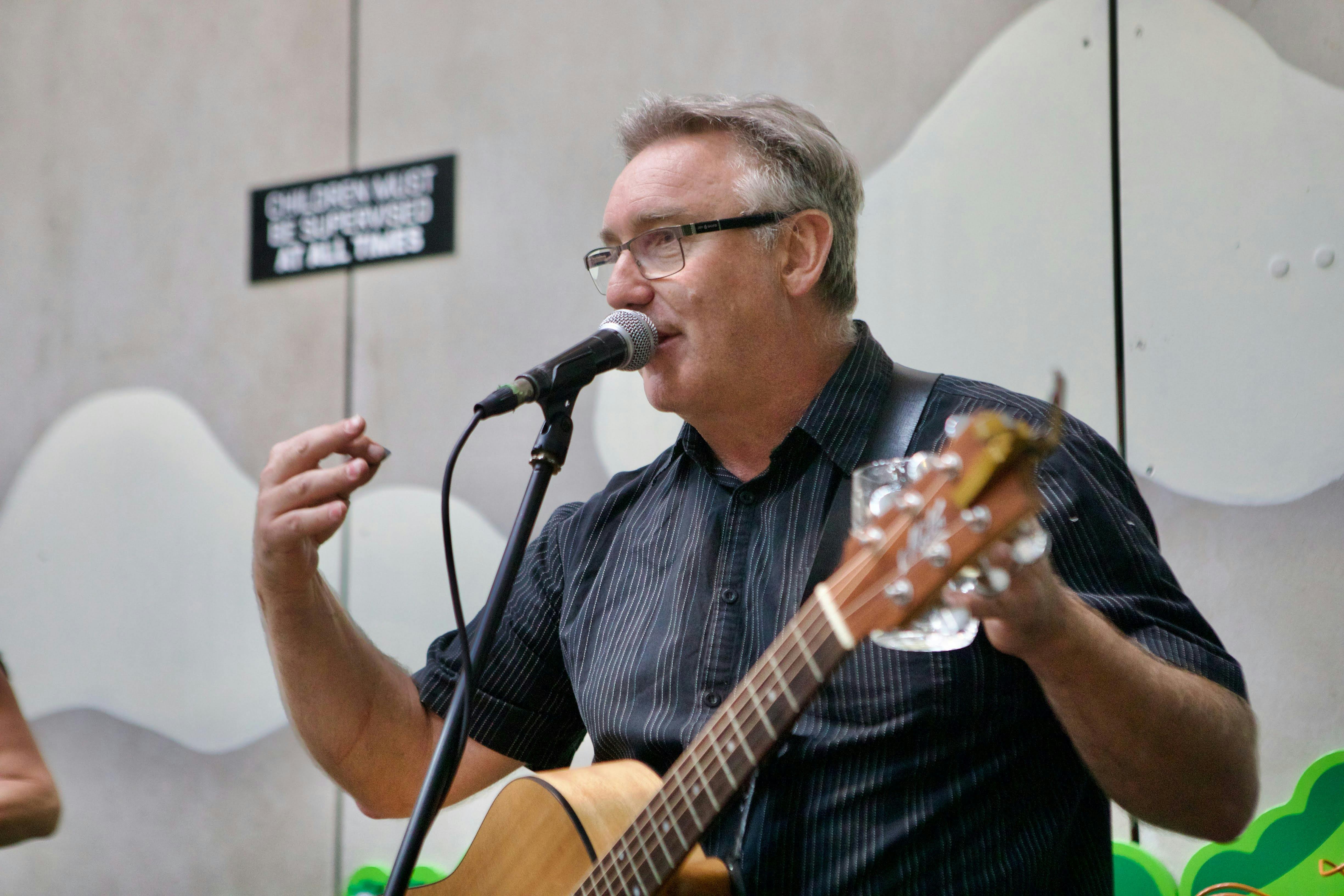 Male guitarist on stage speaking into microphone