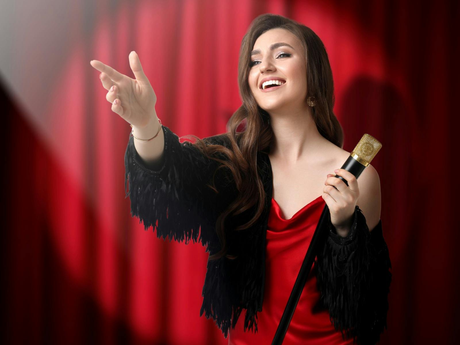 Woman dressed in classic Broadway style with old-fashioned microphone