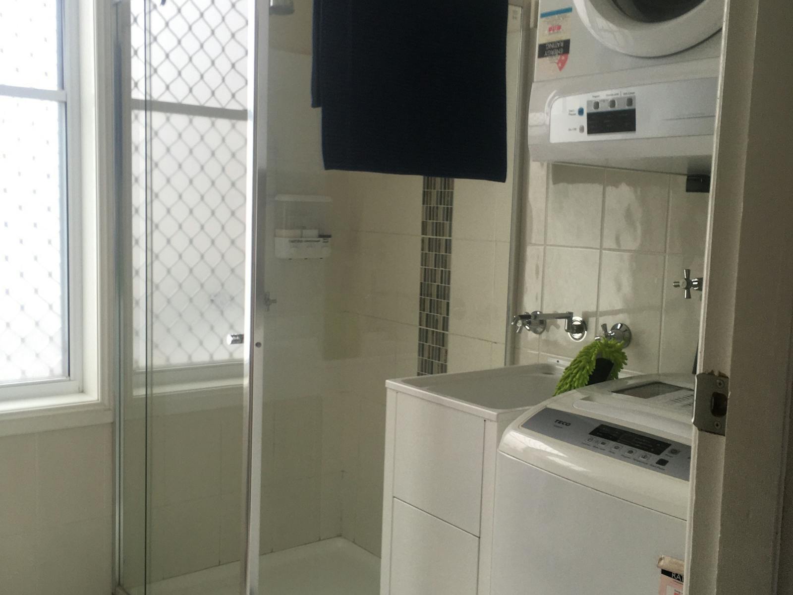 Bathroom Showing Shower, Washing machine & Dryer