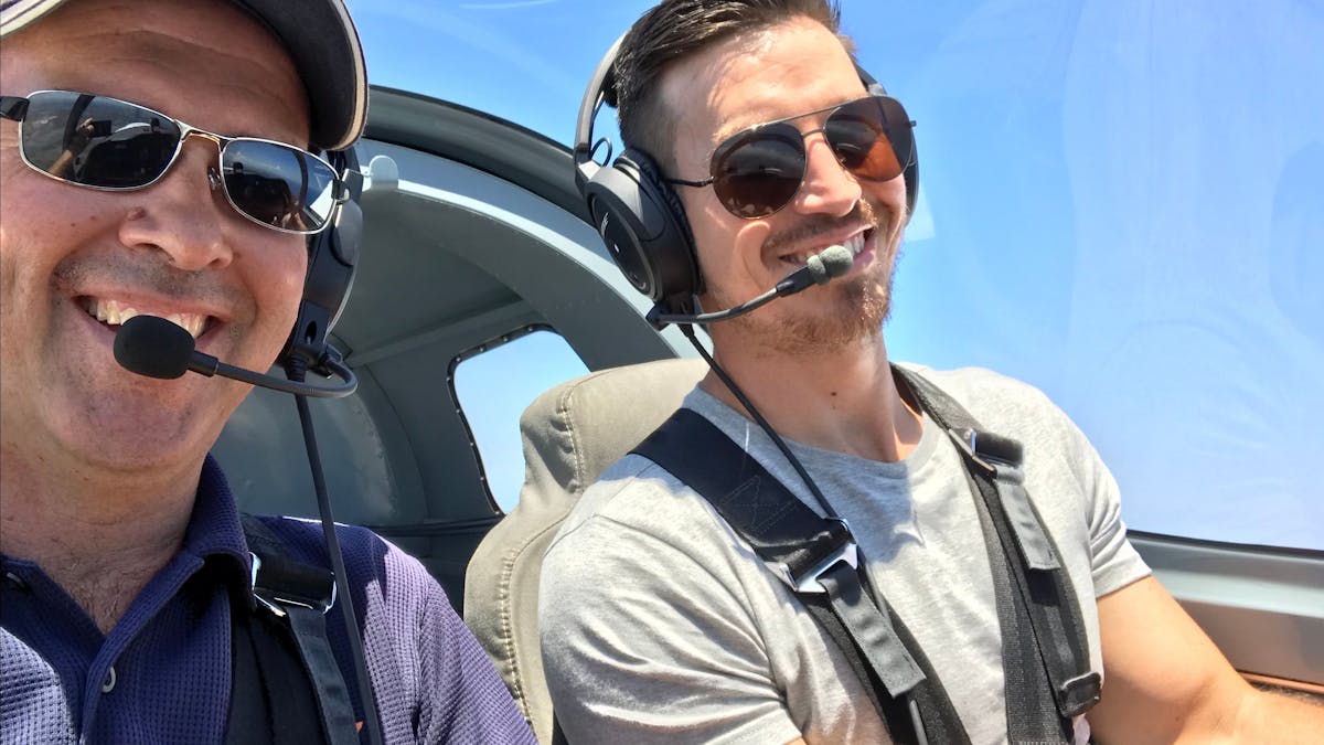Instructor and student flying sling plane