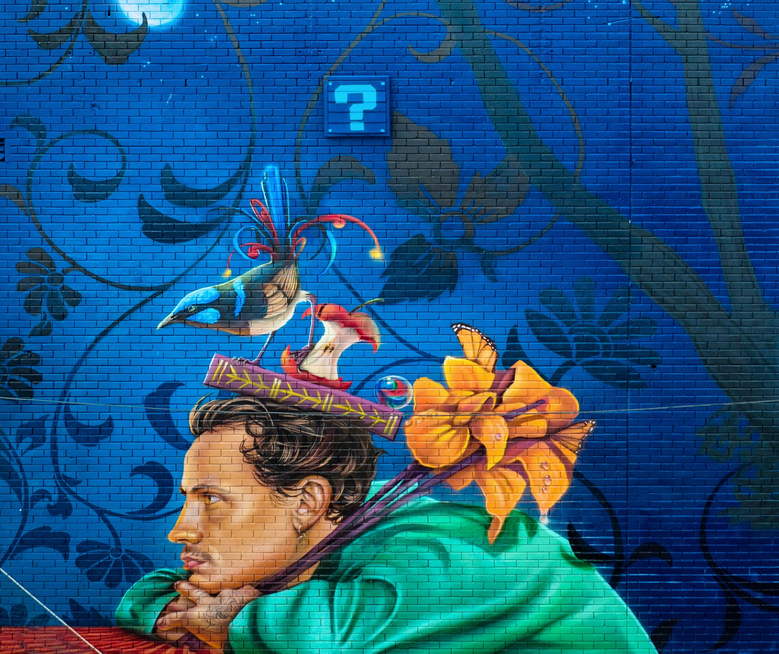 Street art portrait. Man leaning head on crossed arms balancing an apple core on his head.