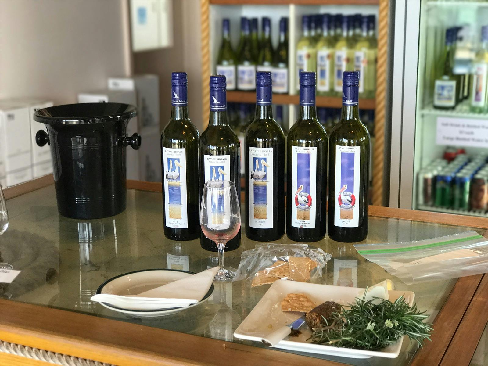 A selection of bay of shoal wines on display with a tasting glass and platter