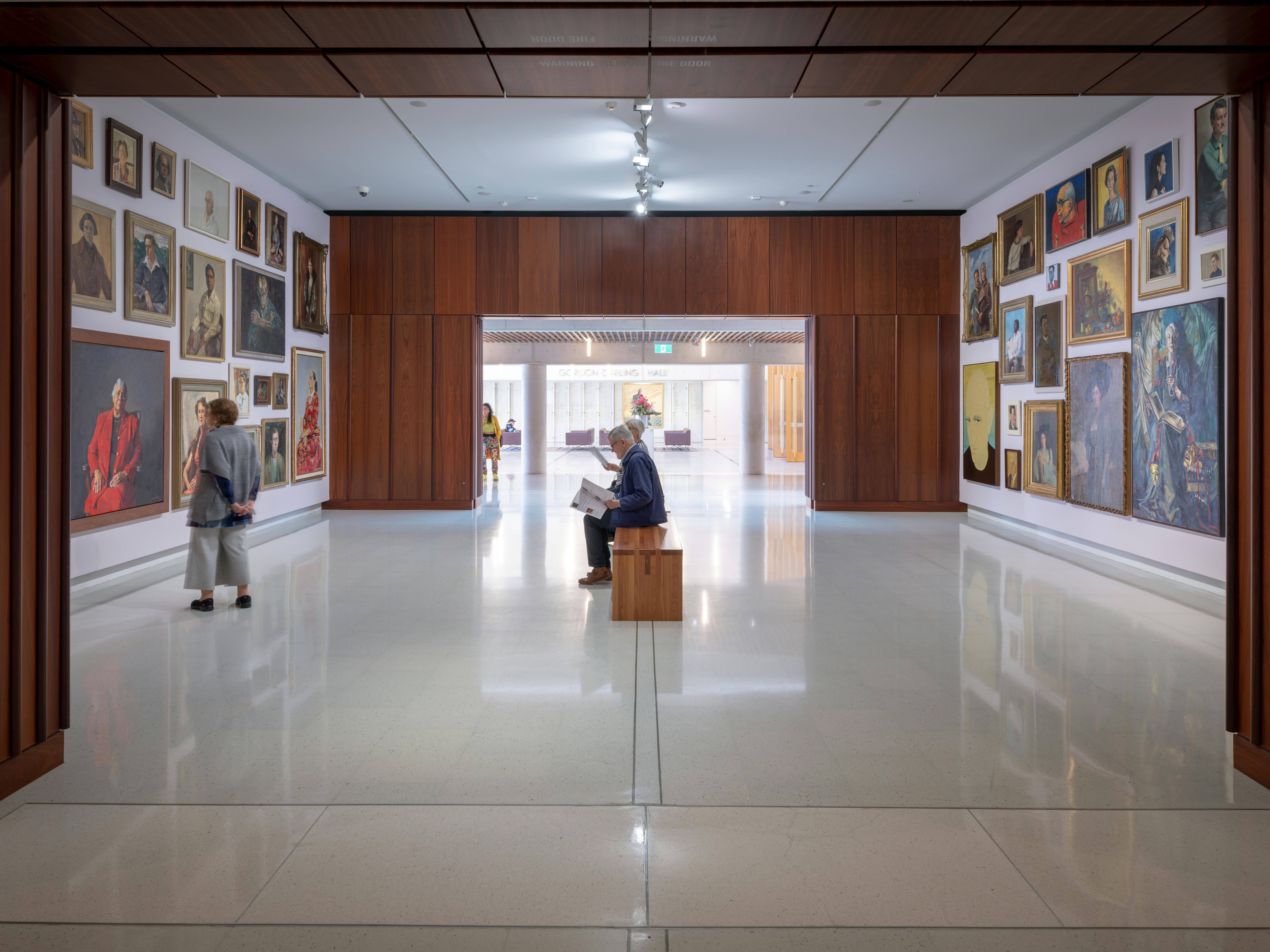 A photograph of Gallery 1 space featuring a salon hang of paintings