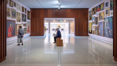 A photograph of Gallery 1 space featuring a salon hang of paintings