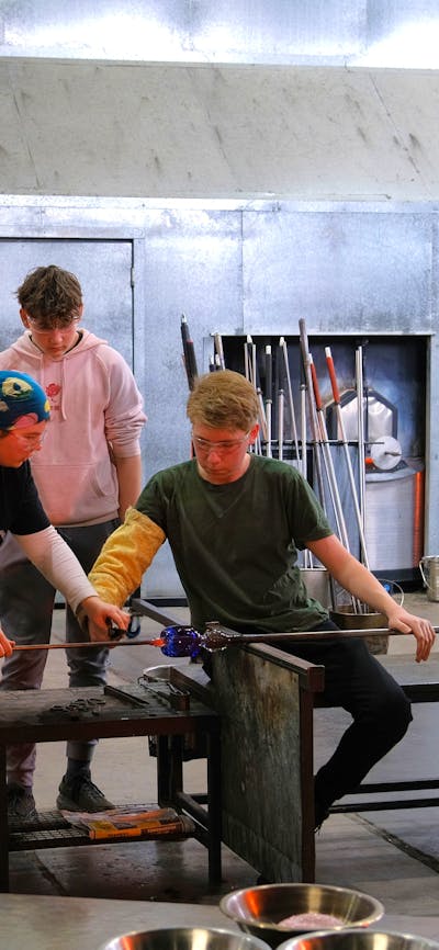 Participants and teacher during glassblowing class
